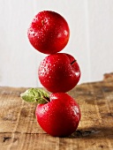Three red plums, stacked