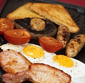 Englisches Frühstück aus Bioprodukte: Speck, Spiegelei, etc.