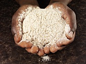 Hands holding wholemeal flour