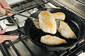 Frying chicken breasts in a frying pan