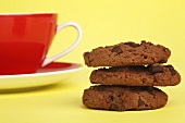 Drei Chocolate Chip Cookies mit einer Tasse