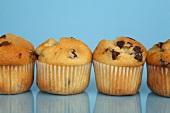 Four chocolate chip muffins in a row