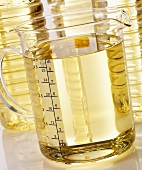 Vegetable oil in a measuring jug and plastic bottles