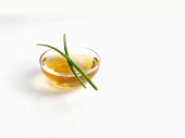 Chives on a small glass dish of oil