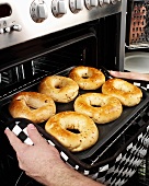 Man taking bagels out of the oven