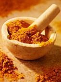 Turmeric powder in and beside a mortar