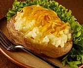 Eine Ofenkartoffel mit geriebenem Cheddar