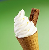 Cone of soft vanilla ice cream with flaky chocolate stick
