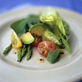 Salad leaves with green asparagus, avocado and tomatoes