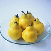 Pear-shaped quinces on a glass plate
