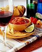 Tortilla chips with tomato salsa and red wine