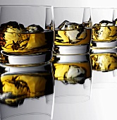 Three glasses of whisky with ice cubes