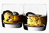 Two glasses of whisky with ice cubes