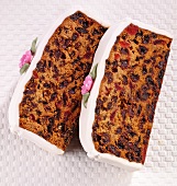 Two slices of fruit cake with white icing