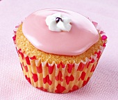 Cupcake with pink icing and white sugar flower