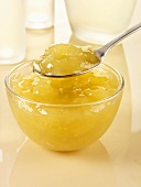 Apple sauce in glass bowl and on spoon
