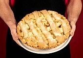 Man holding lattice-top apple pie