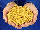 Hands holding spiral pasta