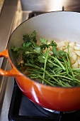 Sweating onions and parsley in a pan for soup