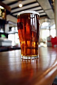 A glass of ale on bar counter (UK)