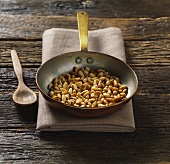 Toasted pine nuts in frying pan