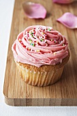 Cupcake with pink icing and hundreds and thousands