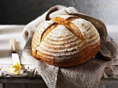 Round rustic bread on a jute bag, butter