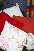 Decorative cushions and small watering can