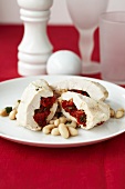 Poached chicken breast stuffed with red peppers on white beans