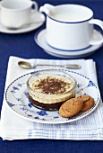 A small dish of chocolate and vanilla mousse with biscuits