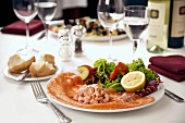 Shrimp cocktail on smoked salmon, garnished with salad leaves