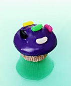 Muffin with purple icing and jelly beans