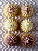 Six cupcakes on wavy background (overhead view)