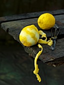 Lemon, partly peeled, on wooden table