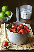 Fresh strawberries in pan, limes, sugar