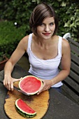 Frau schneidet Wassermelone in Spalten