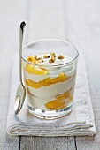 Yoghurt with peach and hazelnuts in glass