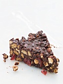 A piece of chocolate refrigerator cake, with nuts, biscuits, glace cherries