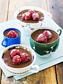 Chocolate pudding with sugared raspberries in cups
