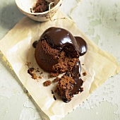Chocolate pudding with chocolate sauce on baking parchment