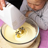 Little girl watching someone making ice cream