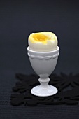 Soft-boiled egg with top removed in egg cup
