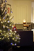 Decorated Christmas tree, dining table in background