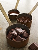 Pieces of chocolate and melted chocolate in pans