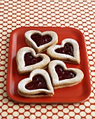 Heart-shaped jam biscuits on tray