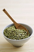 Fennel seeds with wooden spoon in bowl