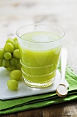 Kiwi fruit and grape juice in glass on small board