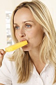 A blonde woman eating an ice lolly