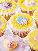 Pastel-coloured fairy cakes with sugar flowers