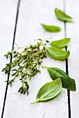 Basil and thyme on a wooden table